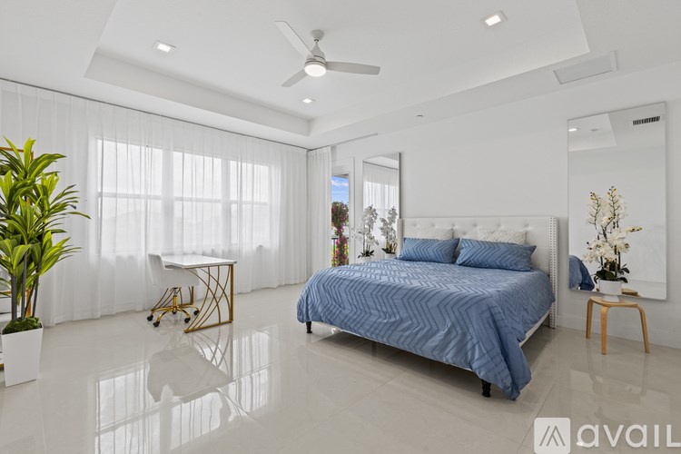 A bedroom with a large bed and a plant on the side table.