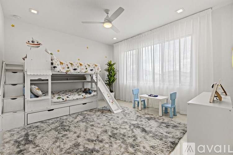 A white bedroom with a bunk bed and a desk.