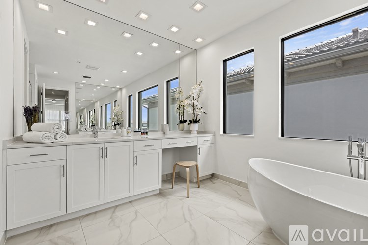 A bathroom with a large tub and a vanity with a mirror.