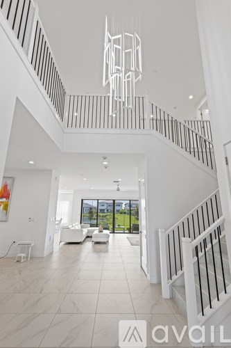 A white interior with a staircase and a painting on the wall.