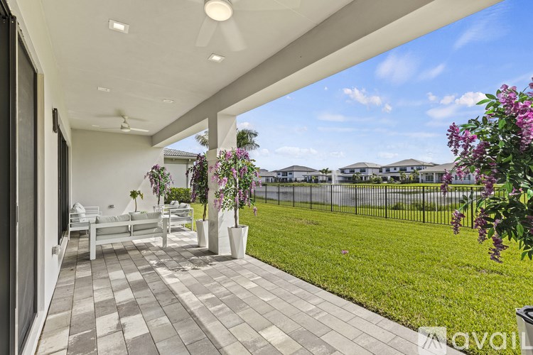 A patio with a white ceiling fan and a white sofa.