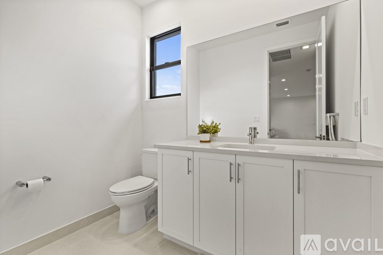 A bathroom with a toilet, sink, and mirror.