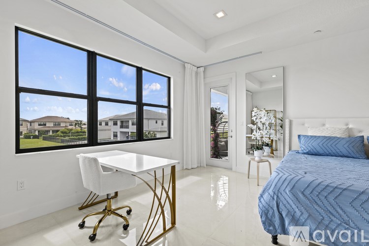 A bedroom with a bed, desk, and chair.