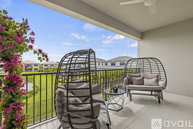 A balcony with two chairs and a table with flowers on the left.