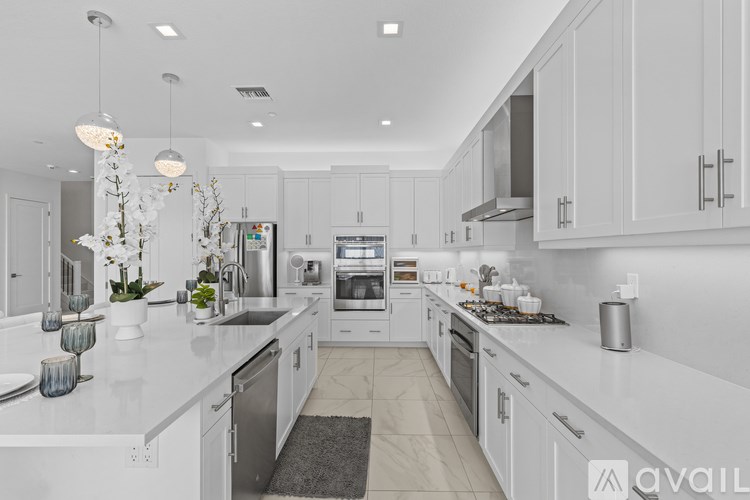 A modern kitchen with white cabinets and appliances.