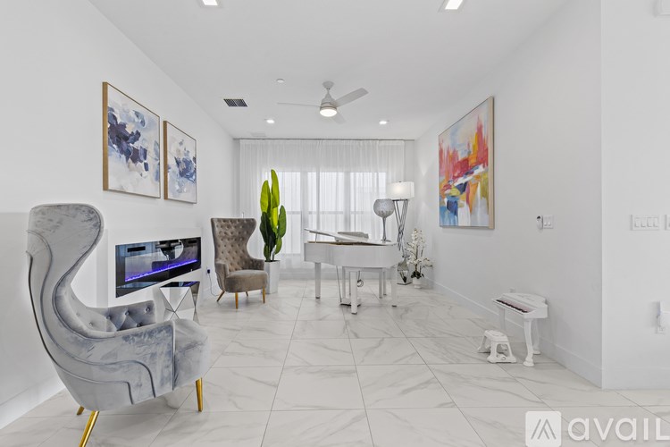 A living room with a TV, a chair, a table, and a painting on the wall.
