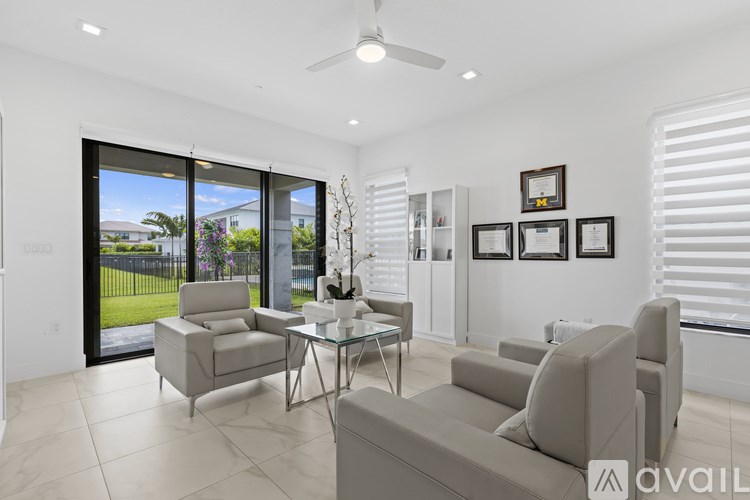 A living room with a glass table and chairs, a ceiling fan, and pictures on the wall.