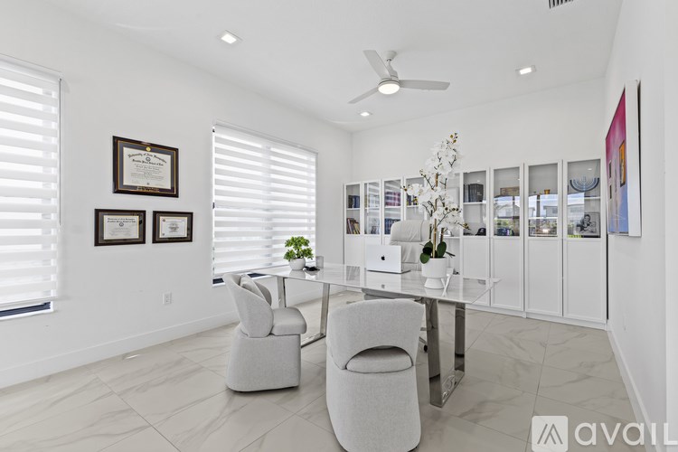 A modern living room with a white color scheme and a large table with chairs.