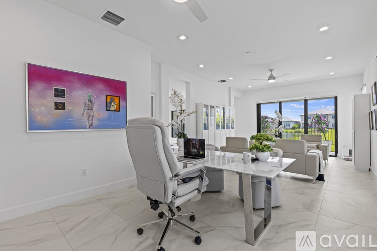 A modern office space with a large painting on the wall and a desk with a chair.