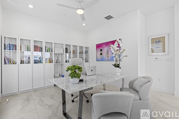 A modern office space with a glass table and grey chairs.