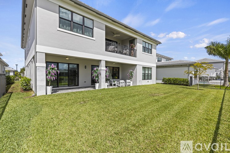 A modern house with a large front yard and a balcony with flowers.
