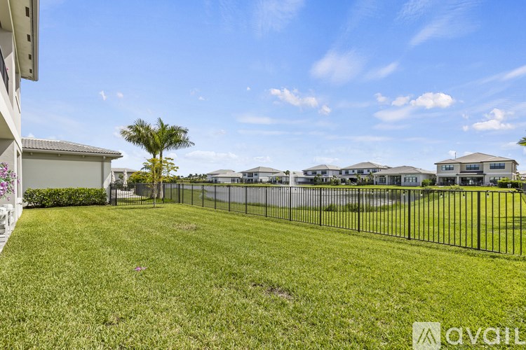 A grassy area with a fence and a building in the background.