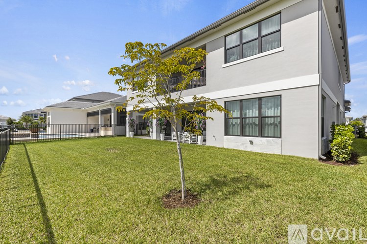 A tree in a yard in front of a house.