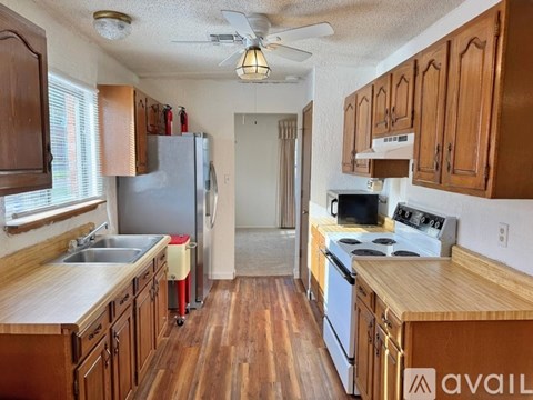 A kitchen with wooden cabinets and a white fridge.