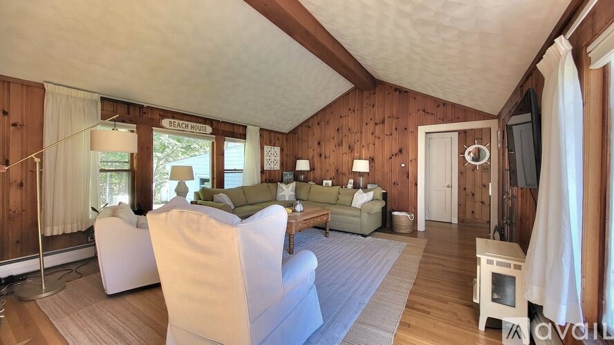 A living room with wooden walls and furniture.
