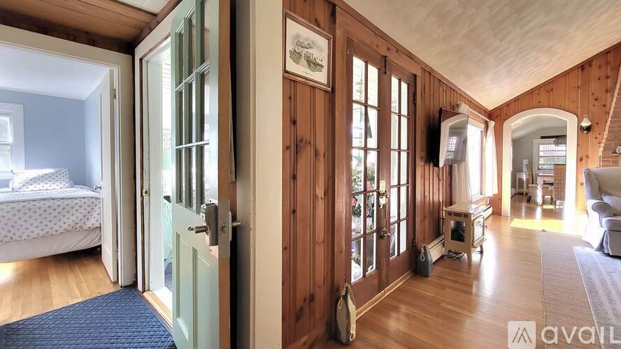 A room with wooden walls and a bed with white bedding.