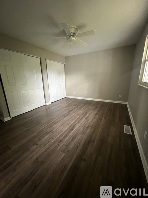 A room with wooden flooring and a ceiling fan.