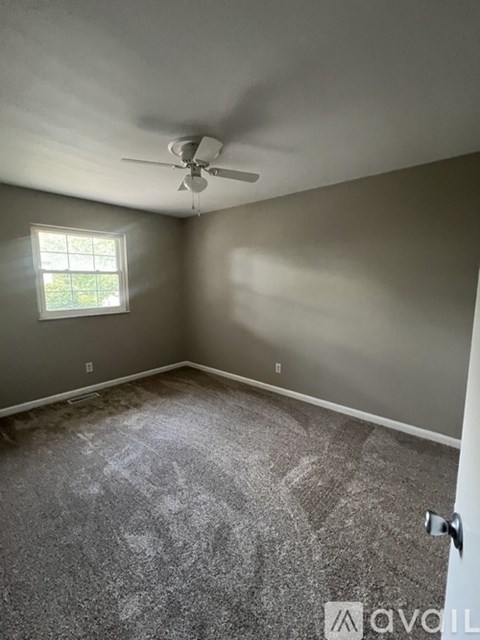 A room with a ceiling fan and a window.