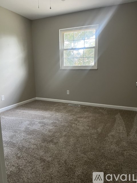 A room with a carpeted floor and a window.