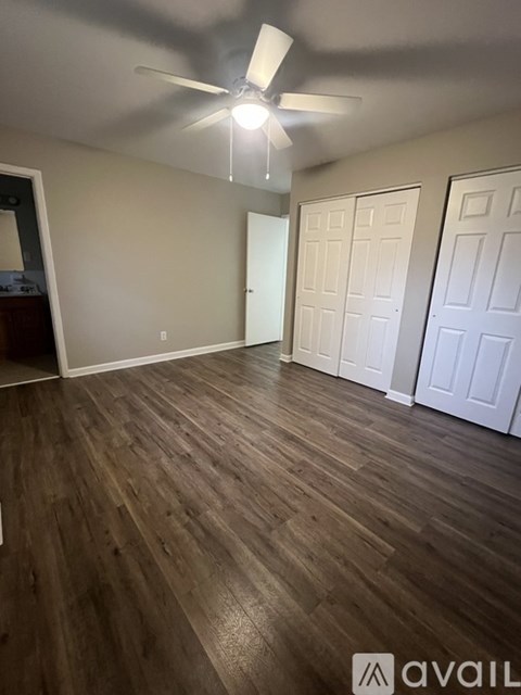A room with wooden flooring and a ceiling fan.