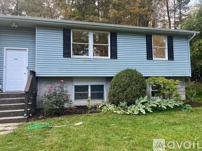A blue house with a white door and windows.