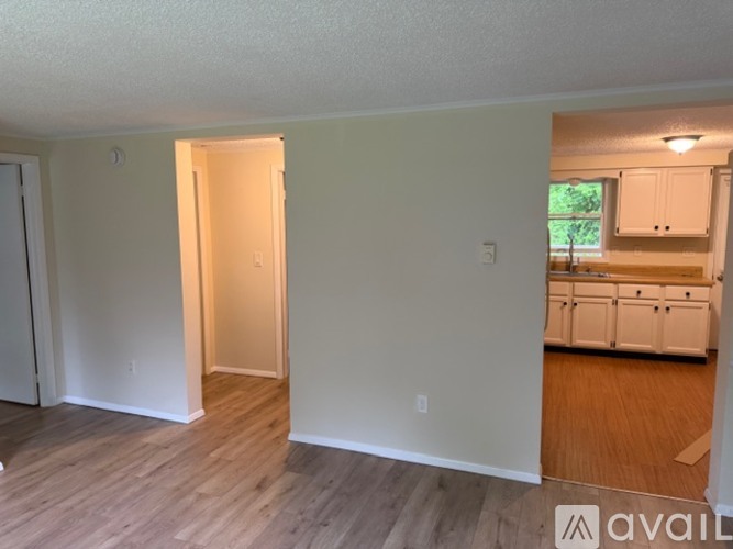 A spacious room with a grey floor and two windows.