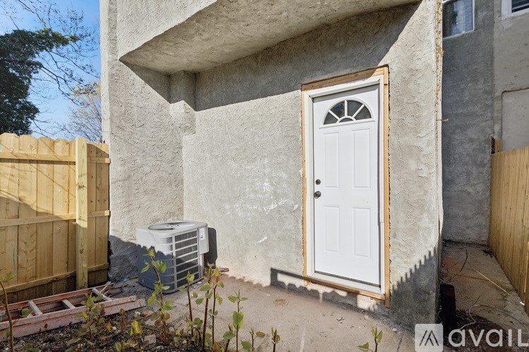 A white door with a window above it is on the side of a house.