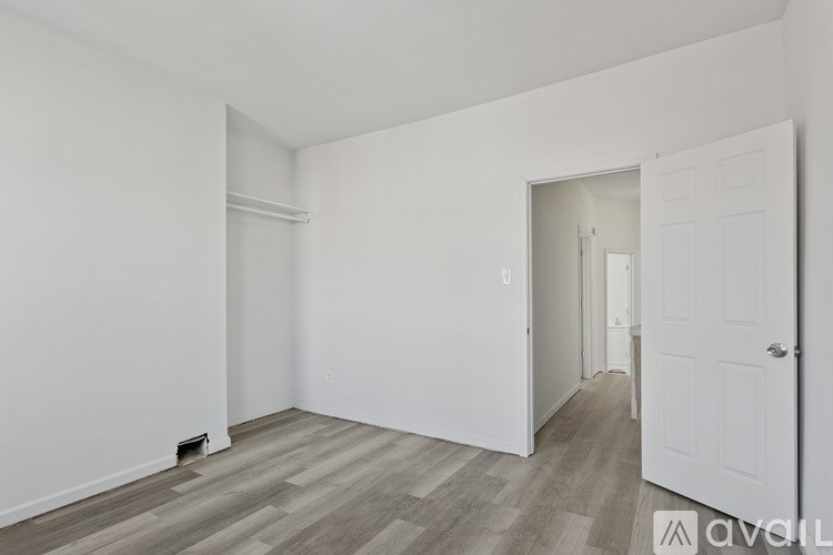 A room with a white door and a white wall.