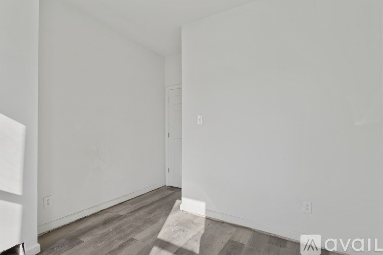 A room with a wooden floor and white walls.