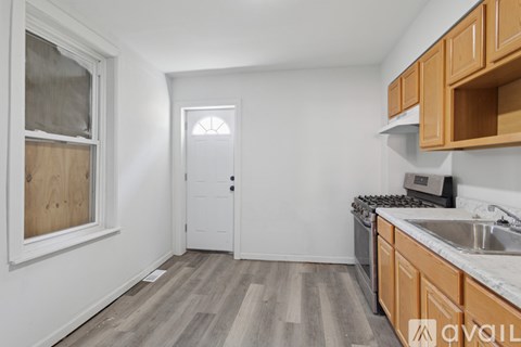 A kitchen with wooden cabinets and a white door.