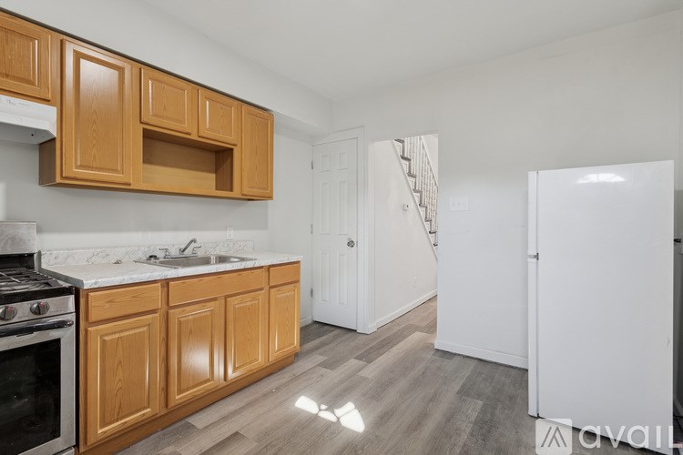 A kitchen with wooden cabinets and a white refrigerator.