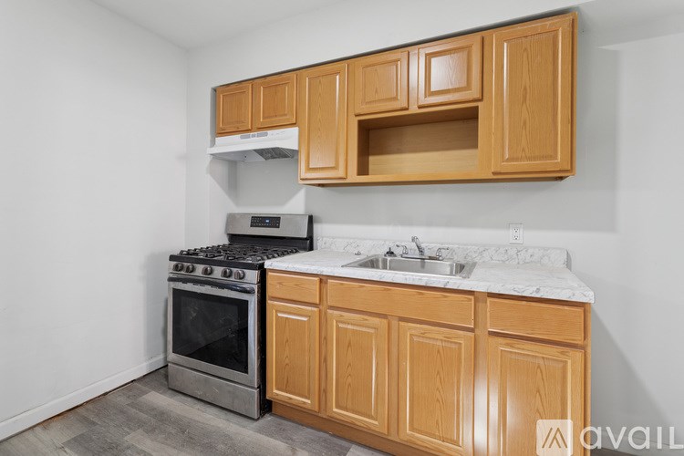 A kitchen with wooden cabinets and a stainless steel stove.