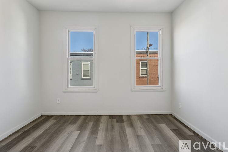A room with two windows and wooden flooring.