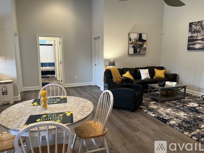 A living room with a couch, chairs, and a coffee table.