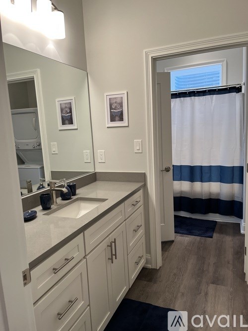 A bathroom with a sink, mirror, and a shower curtain.