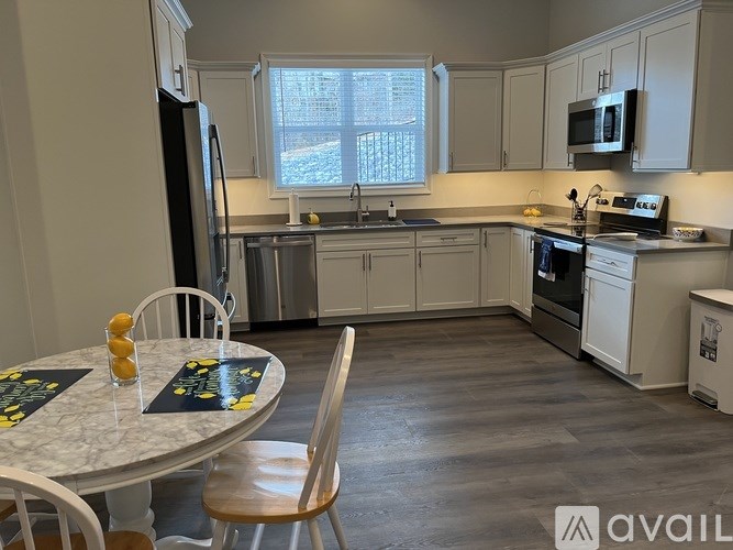 A kitchen with a table and chairs in front of a window.