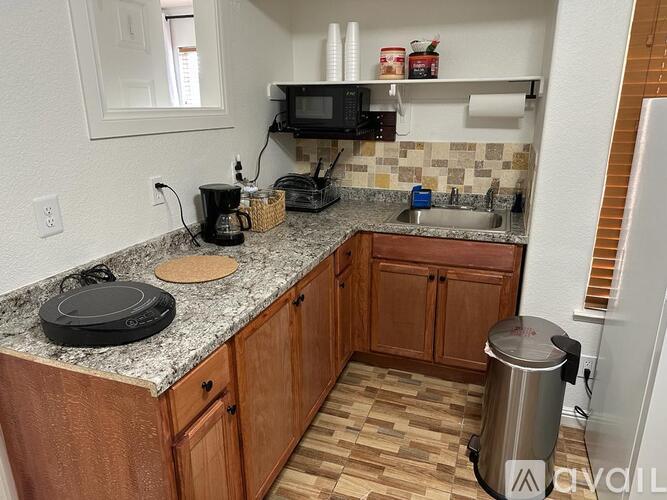 A kitchen with wooden cabinets and granite countertops.