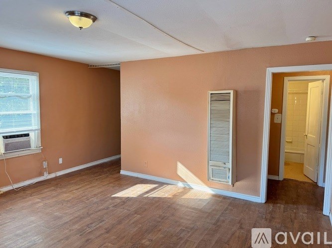 A room with a window and a door is available for rent.