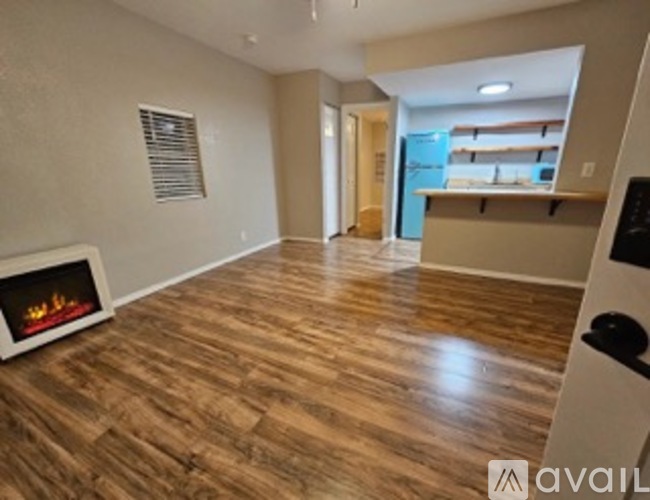 A living room with a fireplace and wooden floors.