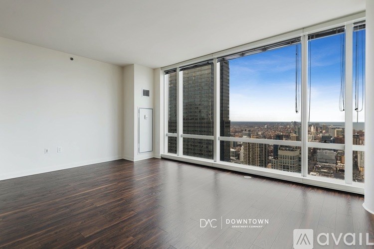 A large empty room with a view of the cityscape outside the window.