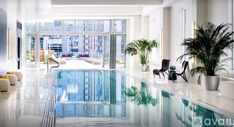 A modern indoor swimming pool with a glass wall in the background.