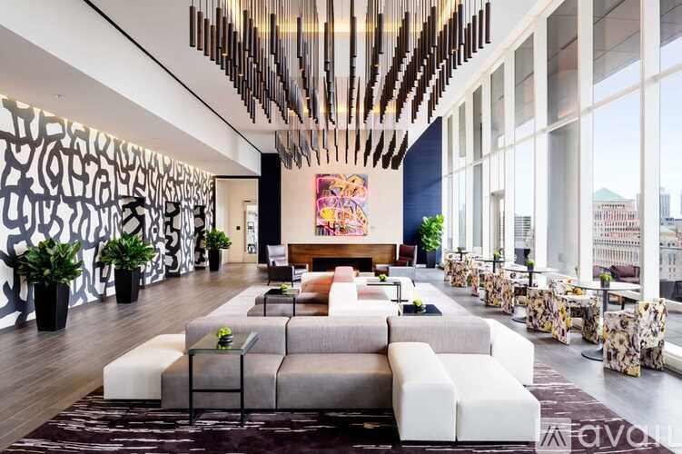 A modern living room with a large grey sofa and a wooden chandelier.