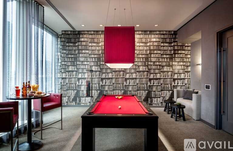 A room with a pool table and a wall of books.