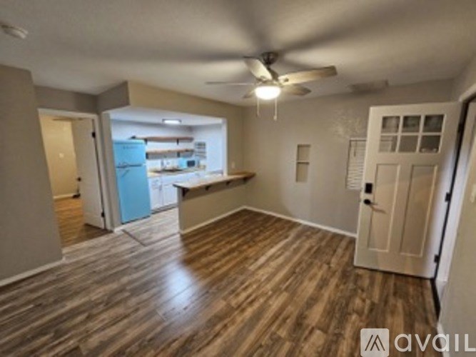 A room with wooden flooring and a ceiling fan.