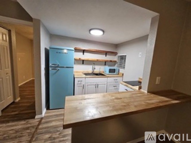 A kitchen with a blue fridge and white cabinets.