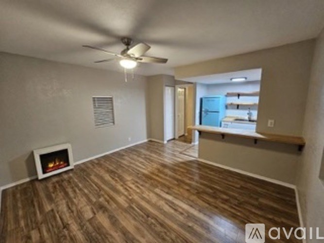 A room with wood flooring and a fireplace.