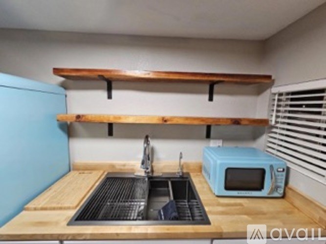 A kitchen with a blue cabinet and a wooden countertop.
