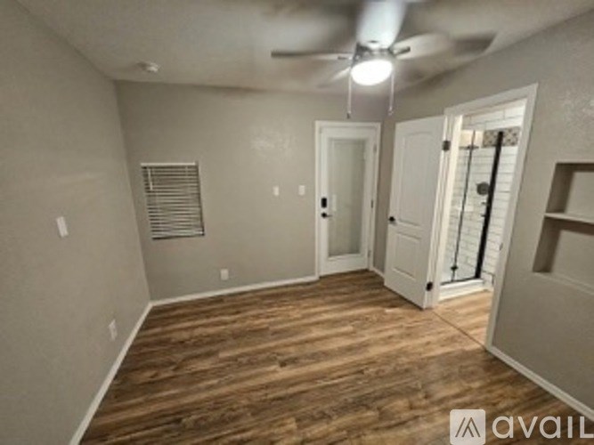 A room with wooden flooring and a ceiling fan.
