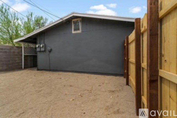 A grey house with a wooden fence in front.