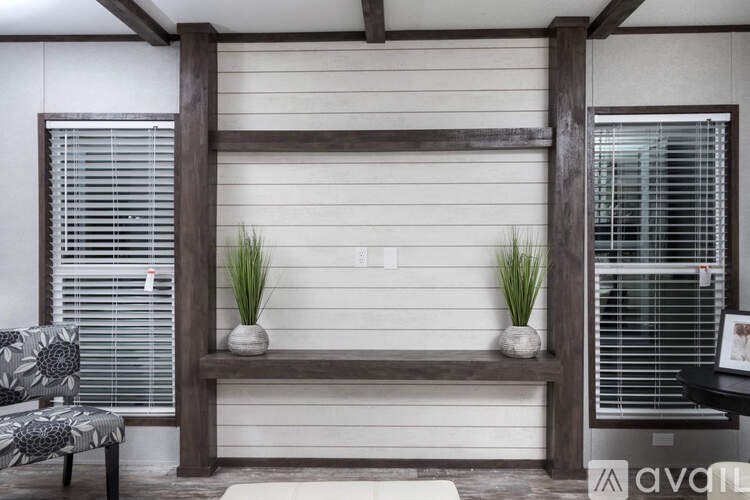 A room with a wooden bench and two potted plants.